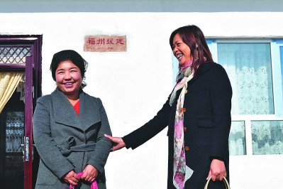 10月26日，奇台县西北湾镇头屯村的哈斯彦·阿不力提领着福州援疆干部陈慧芳参观新房。福州投入资金300万元，帮助奇台县100家贫困户进行危房改造。