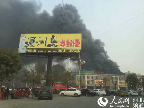 图为保定白沟新腾飞革业有限公司大火引发的浓烟飘散到数米开外。