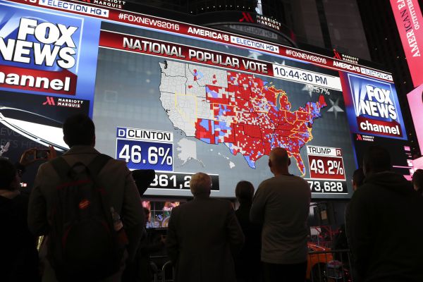 资料图片：11月8日，在美国纽约时报广场，人们关注2016年美国总统大选计票情况。新华社记者王迎摄