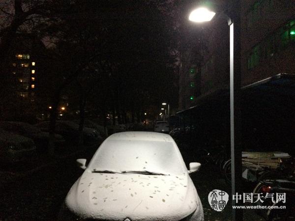 21日早晨，北京海淀区某小区停靠在路边的小车被白雪覆盖。