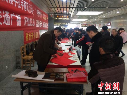 书画家们在徐州站候车大厅为回家的旅客送上“福”字。　朱志庚 摄