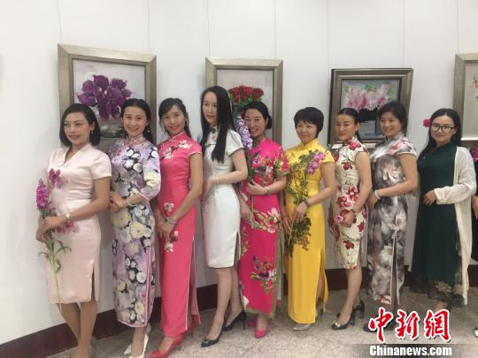 参加活动的女士均身着旗袍，与墙上的一幅幅花卉作品相映成趣。　李凌 摄