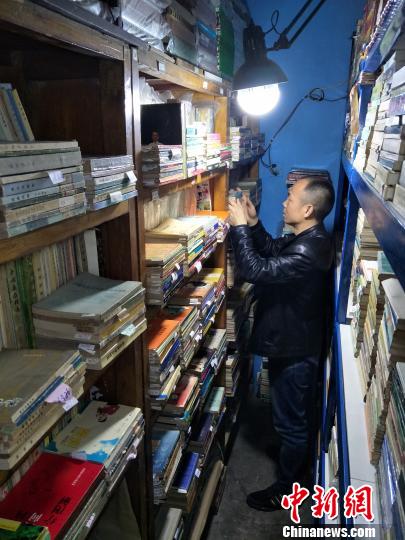 傅天斌总是能准确的找到客人所需的书。　何浠 摄