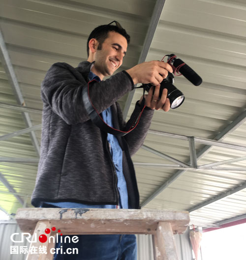 奥里在信阳市茶产业一条街拍摄炒茶工艺。