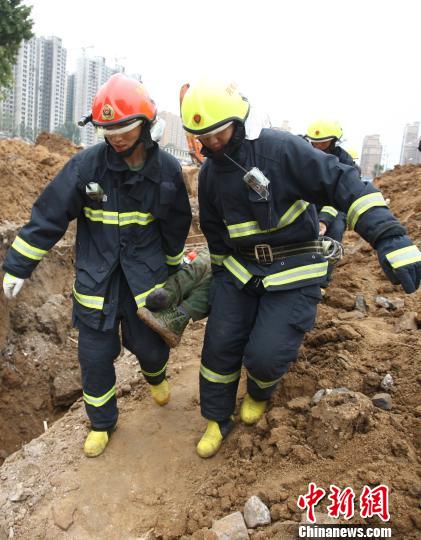 消防人员将被掩埋较深的工作人员救出。　毕西洋摄
