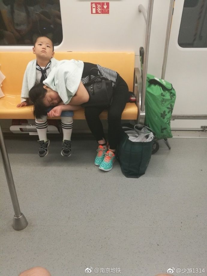 暖心！妈妈地铁趴儿子腿上睡去 小男孩怕坐过站随时报站