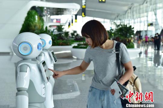 广州白云机场上线“云朵”智能机器人，可多语种交互，吸引众多旅客的注意郭军摄