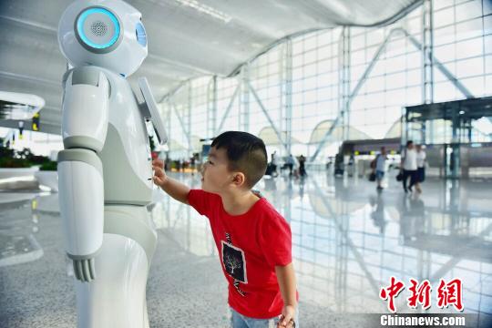 广州白云机场上线“云朵”智能机器人，可多语种交互，吸引众多旅客的注意郭军摄