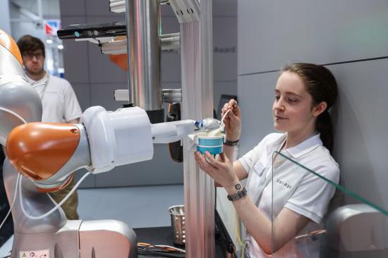 资料图片：今年德国汉诺威工业博览会库卡公司展区拍摄的可自行盛装冰淇淋的机器人。（新华社）