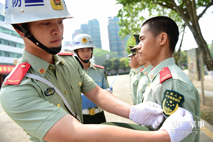 图为部队督察兵对换上新标识的官兵进行督察