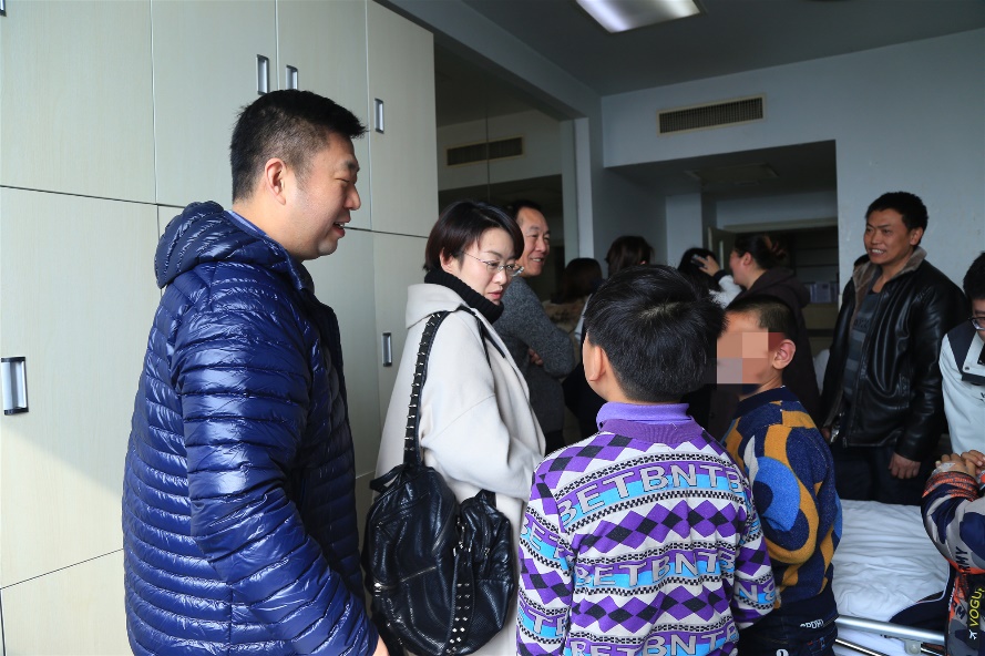 遵义市凤冈县委副书记刘波（左）和贵州师范大学党委统战部部长姚作舟（右）看望等候手术的孩子和家长