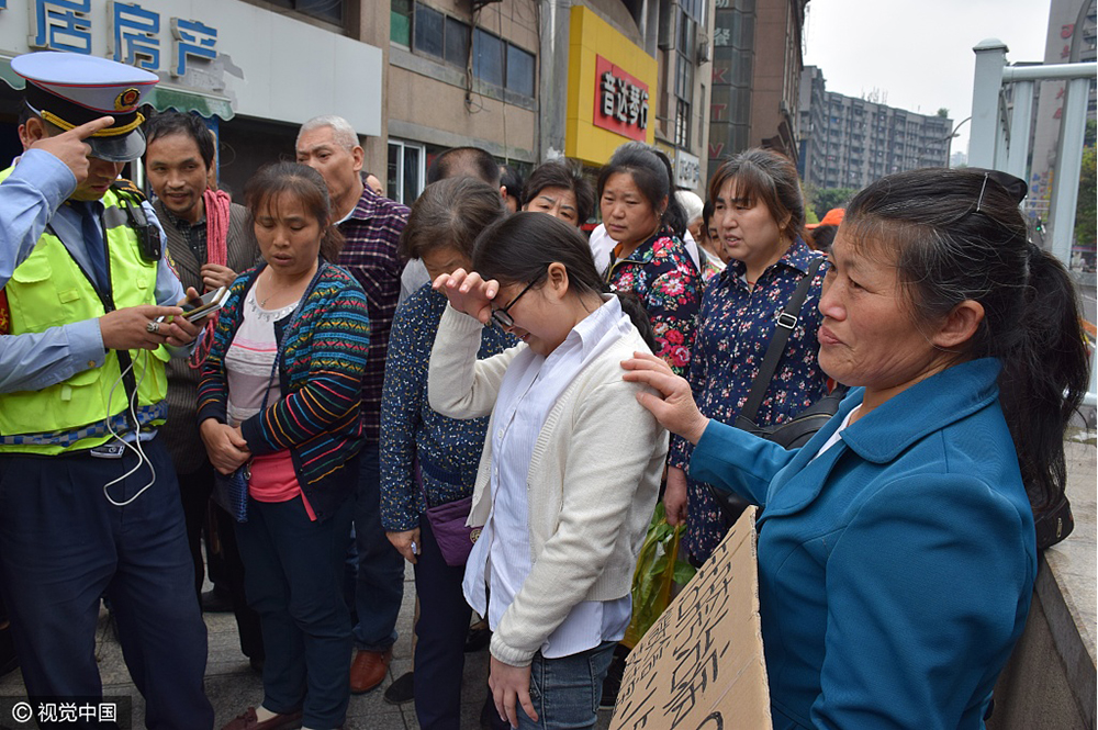 在地上擺放著三沓醫院診斷證明,李娟稱願鑽路人胯下,為身患白血病的