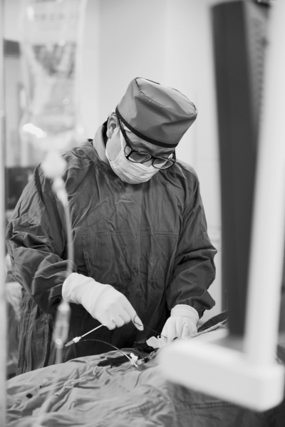 ②手术室里,林瑞祥正在仔细地把手中的导管和导丝准确地送到病人的