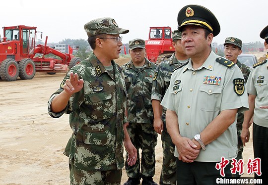 旅游公路的武警交通部队指挥部副司令许钢峰及当地官员到现场指挥作业