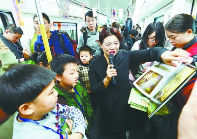 图为孩子们在地铁上和老师一起阅读.记者周迪 摄